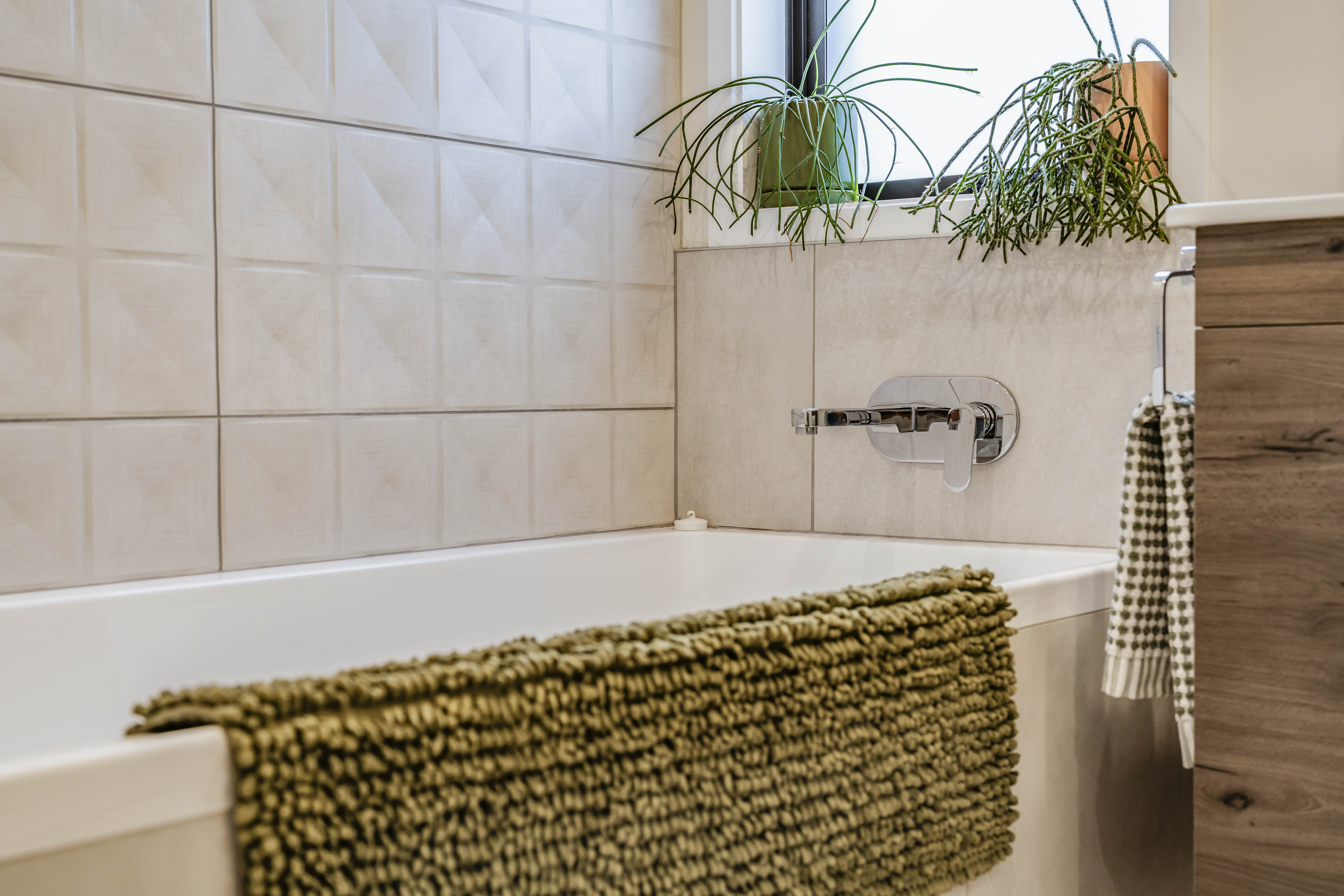 Modern bathroom with built in bath and textured feature tiles   Hobsonville Point   Jev Matt