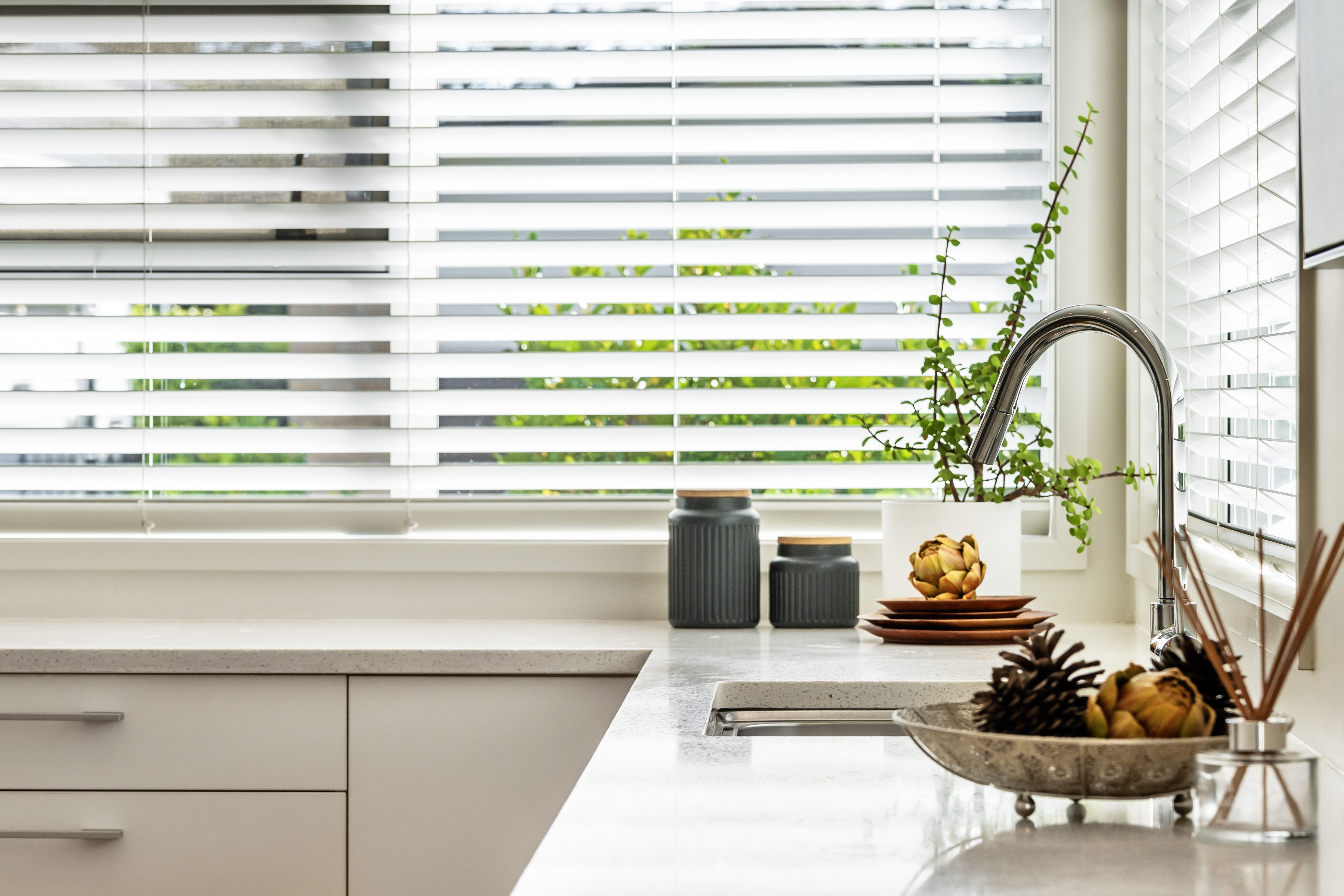 Modern kitchen with stone benchtops and natural light Hobsonville Point Jev Matt