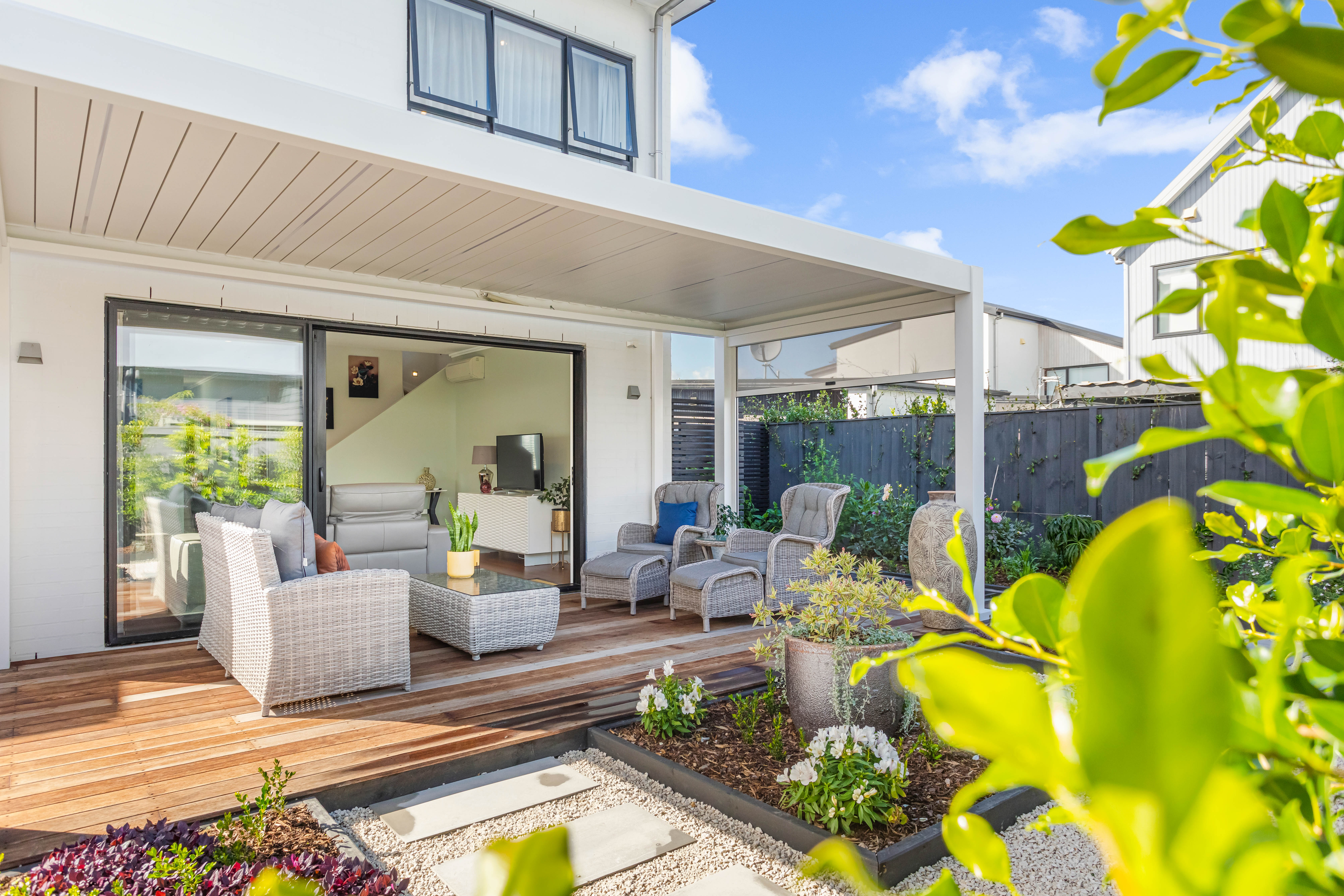 Sunny outdoor entertaining area with covered deck and landscaped garden Hobsonville Point Jev Matt.jpg